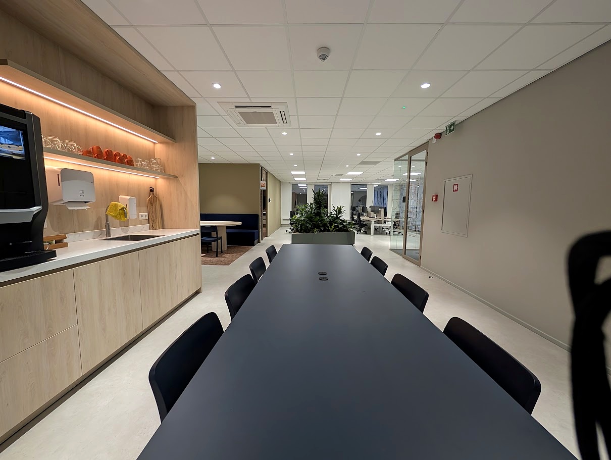kantoor pantry met lange overlegtafel en maatwerk keuken project landelijke busmaatschappij Utrecht