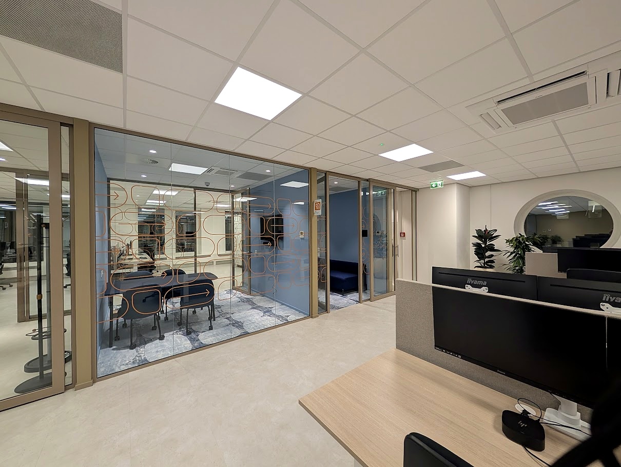 kantoorinterieur met werkplekken en glazen vergaderruimte project landelijke busmaatschappij Utrecht