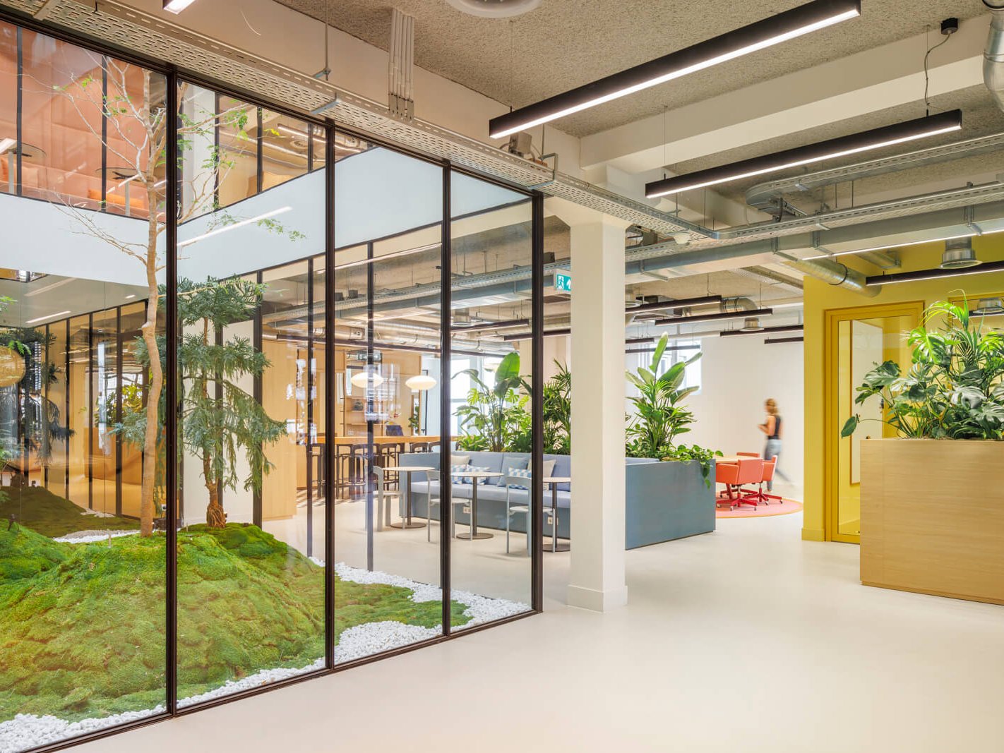 kantoorinterieur met glazen vergaderruimtes en binnentuin met beplanting project grote reisorganisatie Amsterdam