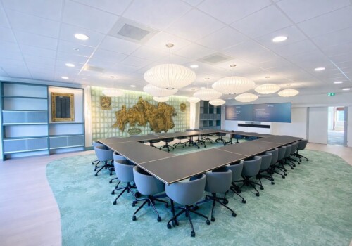 Kantoorgebouw elektriciteitscentrale grote vergaderruimte met U-opstelling tafels en design verlichting project kantoor energiecentrale Geertruidenberg